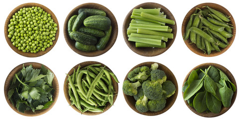 Green vegetables isolated on a white background. Brocoli, green peas, cucumbers and leaves parsley, celery, spinach in wooden bowl with copy space for text. Top view.
