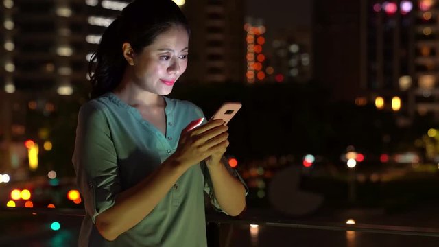 Girl using smartphone on background illumination glow
