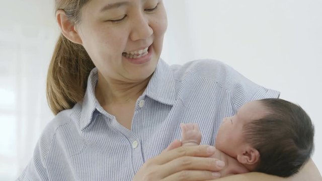 4K Slow motion Happy Asian mother hugging her newborn baby daughter at home, Happiness moment of Asian family