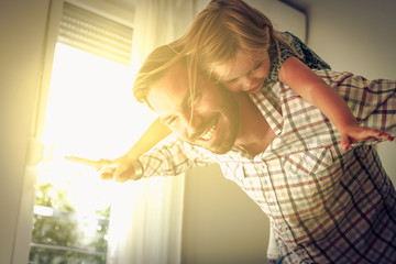 Young dad with cute daughter at home have play together.