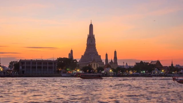 Zoom in time lapse of Big pagoda in Wat Arun Ratchawararam Ratchawaramahawihan / Wat Arun Landmark of Thailand in Sunset time