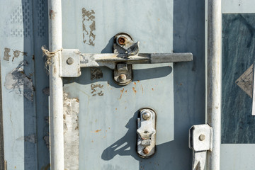 Close-up view of the worn door handle lock of an intermodal shipping container.