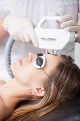 woman during face laser therapy in cosmetics