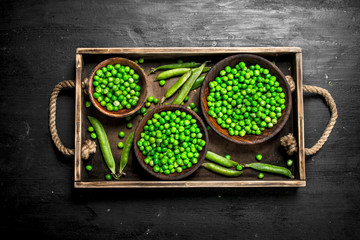 Obraz na płótnie Canvas Fresh green peas in a bowl. On black chalkboard.
