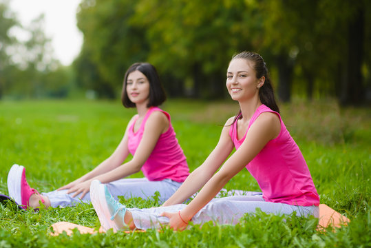 Fitness sport girls in sportswear doing yoga fitness exercise outdoor