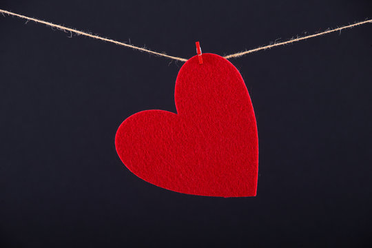 Red paper heart hanging on the clothesline
