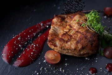Fried meat steak on a black background