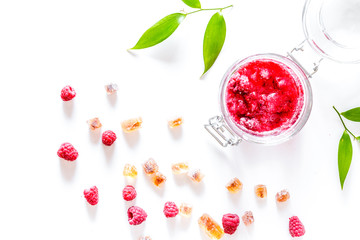 Raspberry jam in glass jar on white background top view copyspac