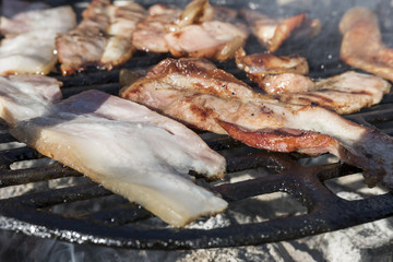 Grilling bacon, pork chop with delicious toasted traces. Smoke. Close up view