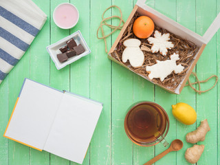 Glass cup of black tea, chocolate and gingerbread gingerbread on a mint-colored table