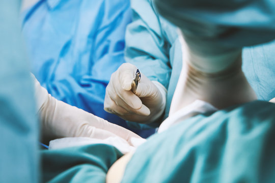 Detail of surgeon holding scalpel in maternity ward operating theatre