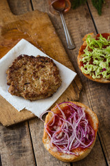 Burger with chop, cheese, onion and tomato sauce