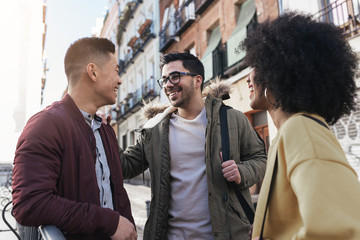 Group of happy friends chatting in the street.