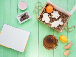 Glass cup of black tea, chocolate and gingerbread gingerbread on a mint-colored table