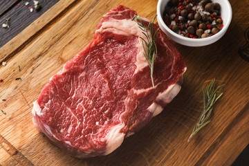 Raw beef filet mignon steaks on wooden board