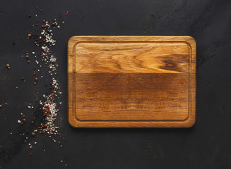 Wooden cutting board on dark wooden background