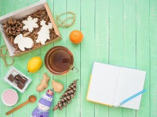 Glass cup of black tea, chocolate and gingerbread gingerbread on a mint-colored table
