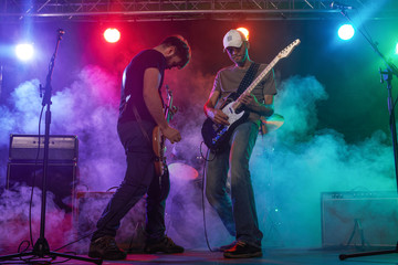 Fototapeta na wymiar Guitarist and bass player perform on stage.