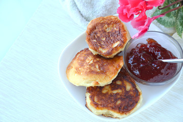 Homemade fritters with jam on a white plate