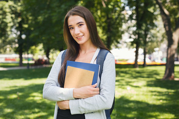 Fototapeta premium Student girl with books in park outdoors