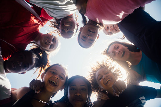 Low angle view of schoolgirl soccer team huddled in circle