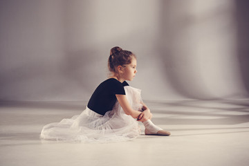 The little balerina dancer on gray background