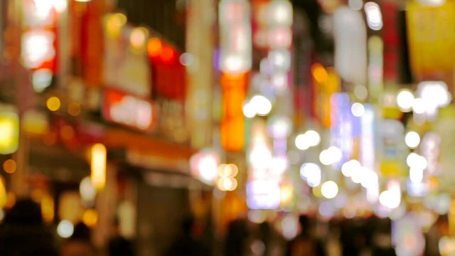 Blurred video of night city, people walking at street with illuminated shopping malls. Japan, Tokyo, Shinjuku district.