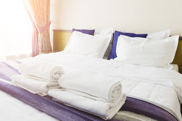 White towels on bed in hotel bedroom
