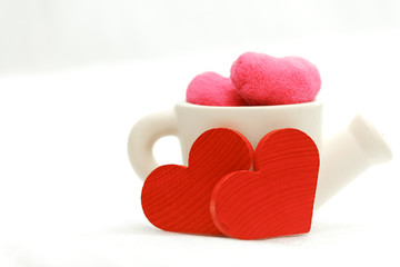 Red wooden heart with white cup on white background.