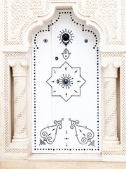 white Arab door with fatima hands in tunisia at Mahadia