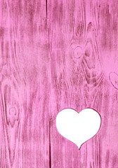 White heart carved in a wooden pink board. Background.