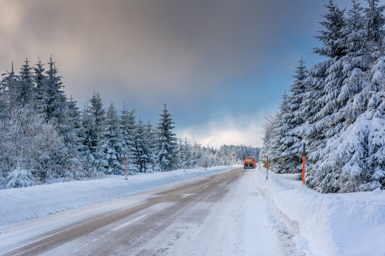 Wintertime - Black Forest. Winter landscape with snowplow clearing road after snowstorm.
