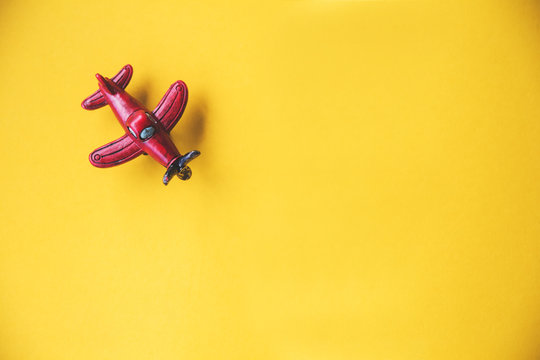 red toy plane on yellow background