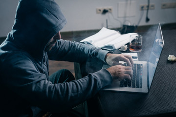 An experienced hacker working on a laptop at home