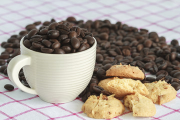 Cup Of Coffee With Cookies And Roasted Coffee Beans On Table In Morning.