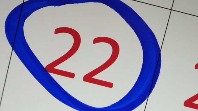 The Blue Marker Circled 22th Red Date On The Calendar