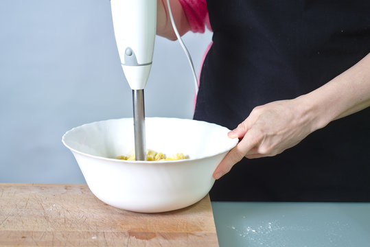 Mujer haciendo un postre casero con batidora