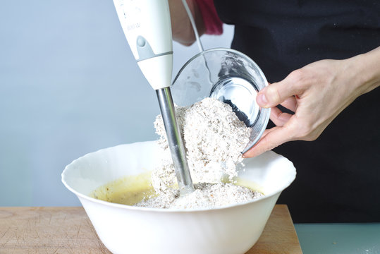 Mujer haciendo un postre casero con batidora