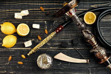 Dismantled parts of hookah on a wooden background with lemon fru