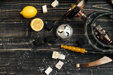 Dismantled parts of hookah on a wooden background with lemon fru