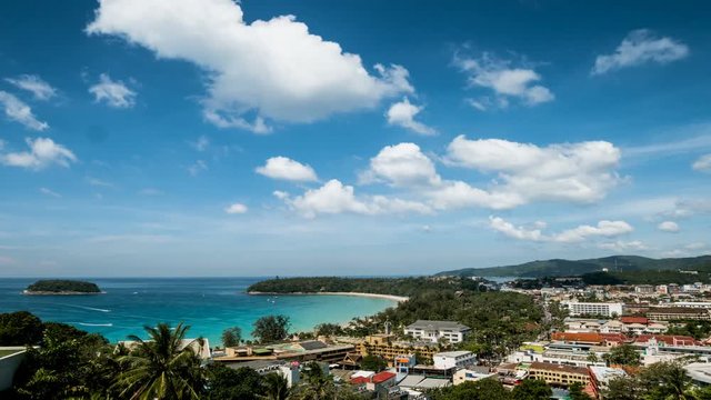 Time lapse travel video view of kata beach and kata city in phuket with boat traffic on the sea and moving clouds in 4k or UHD Resolution.