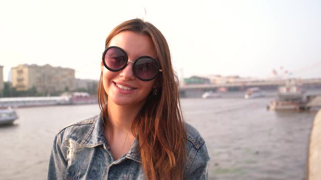 Pretty young woman smiles enjoys city looking at camera 4K