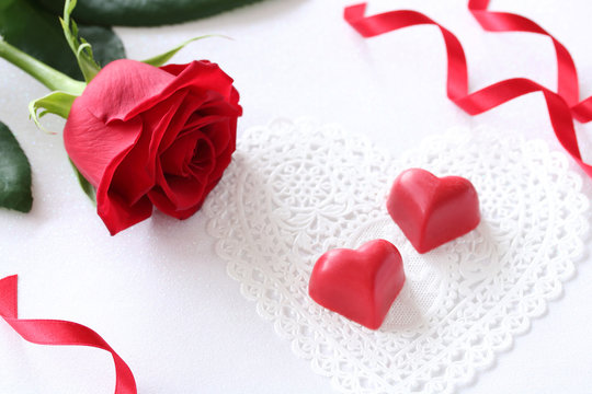 Valentines day background with chocolate hearts and red rose
