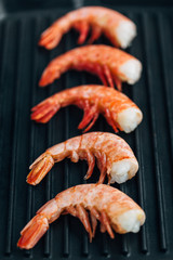 Shrimps on a grill frying pan. Healthy Seafood. Five prawns