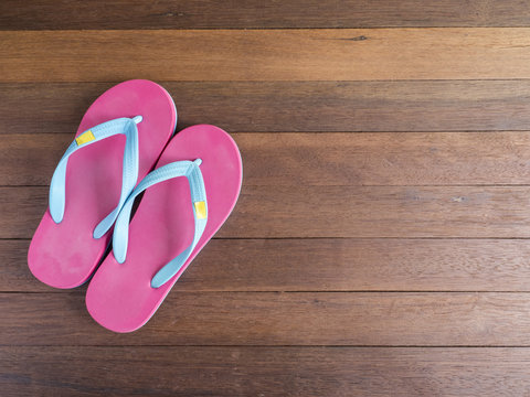 Pink flip flop on wooden floor 3