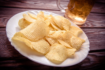 Potato chips and beer on a wooden table