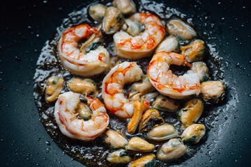 Fried king prawns and mussels in a frying pan. Healthy seafood