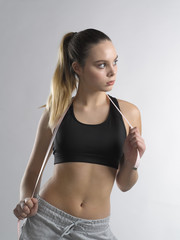 Fototapeta premium Young fitness girl with flexible ruler on shoulders looking sideways.