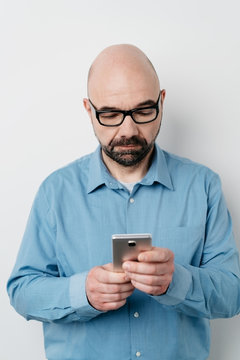 Portrait of serious man sending messages on mobile