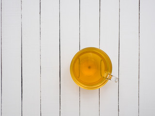 Glass cup of green tea on a white wooden table